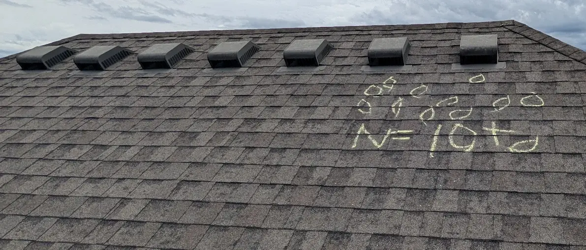 Residential roof inspection showing chalk-marked hail damage on shingles in the Joplin MO and Springdale AR area by MIDWESTGuard llc.